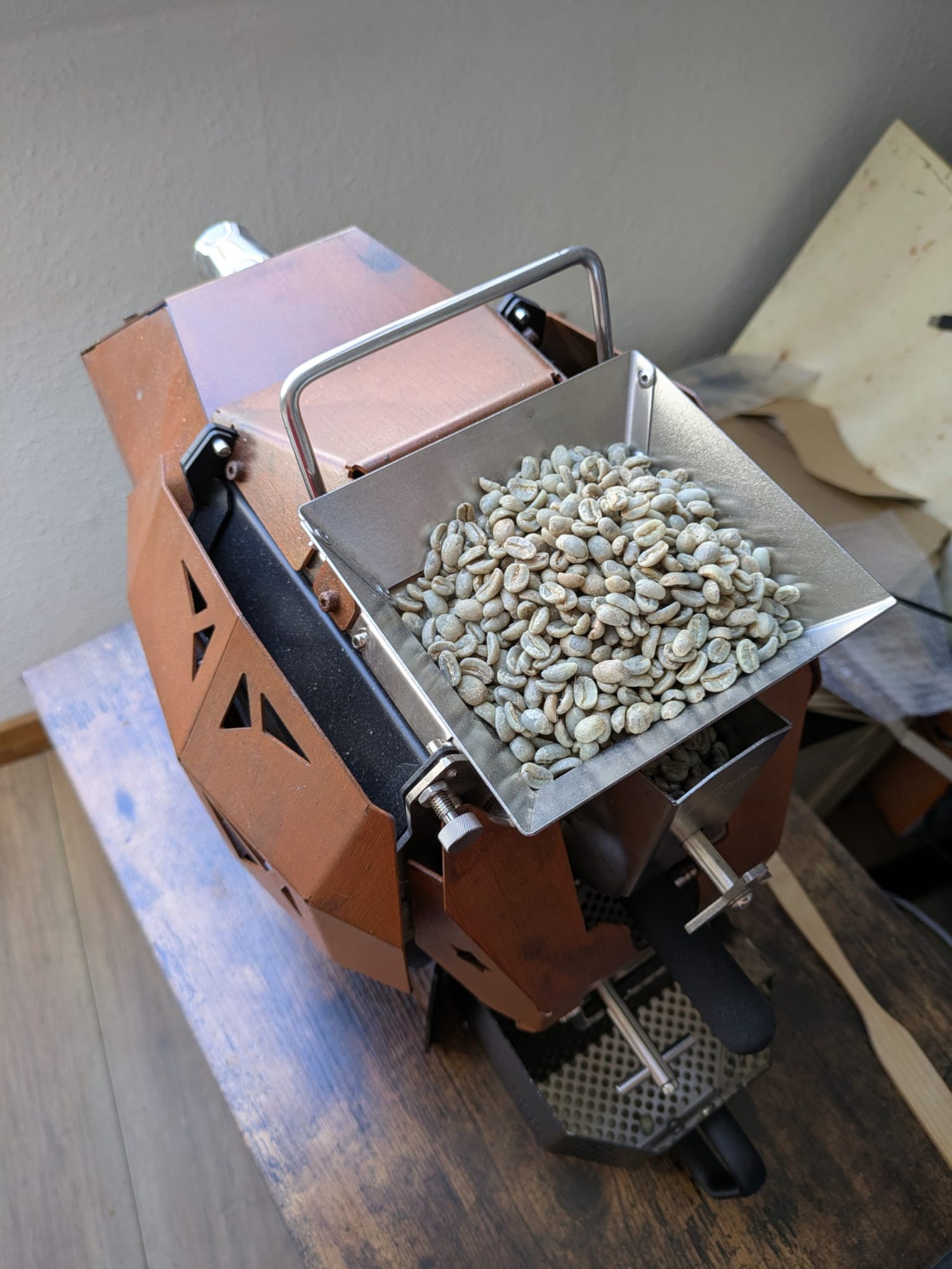 Coffee roaster with green coffee beans loaded ready to drop into the hot roaster.